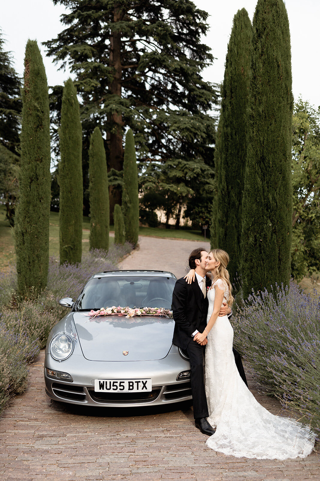 Valentina e Andrea accanto all’auto tra i cipressi